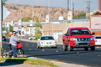 A bicyclist waits for traffic to clear as she tries to cross Historic Highway 66 near the Gallup Cultural Center Friday. © 2011 Gallup Independent / Cable Hoover 